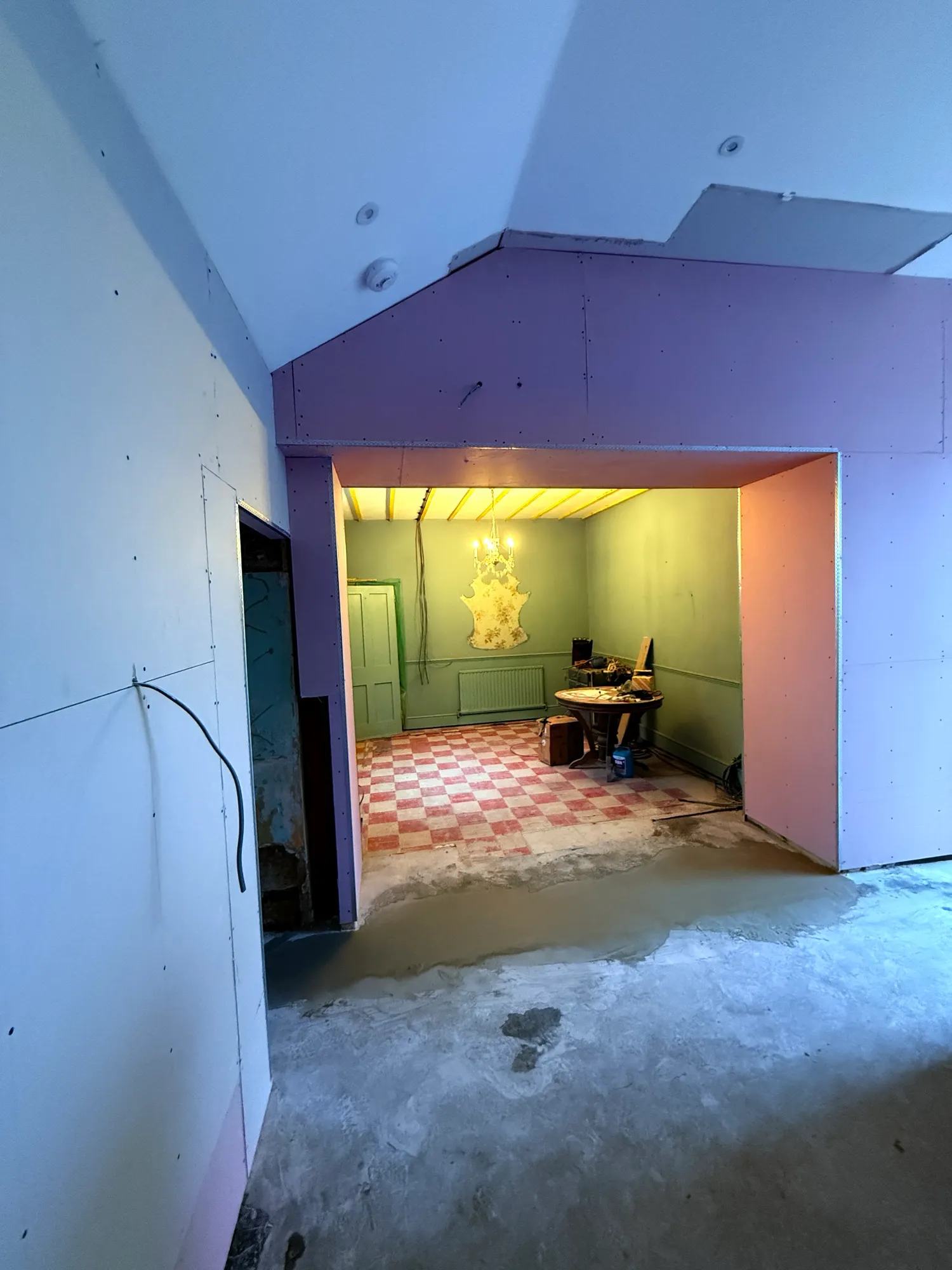 View looking back towards the former dining room with the newly plasterboard walls and pillars supporting the new opening in the former exterior wall.