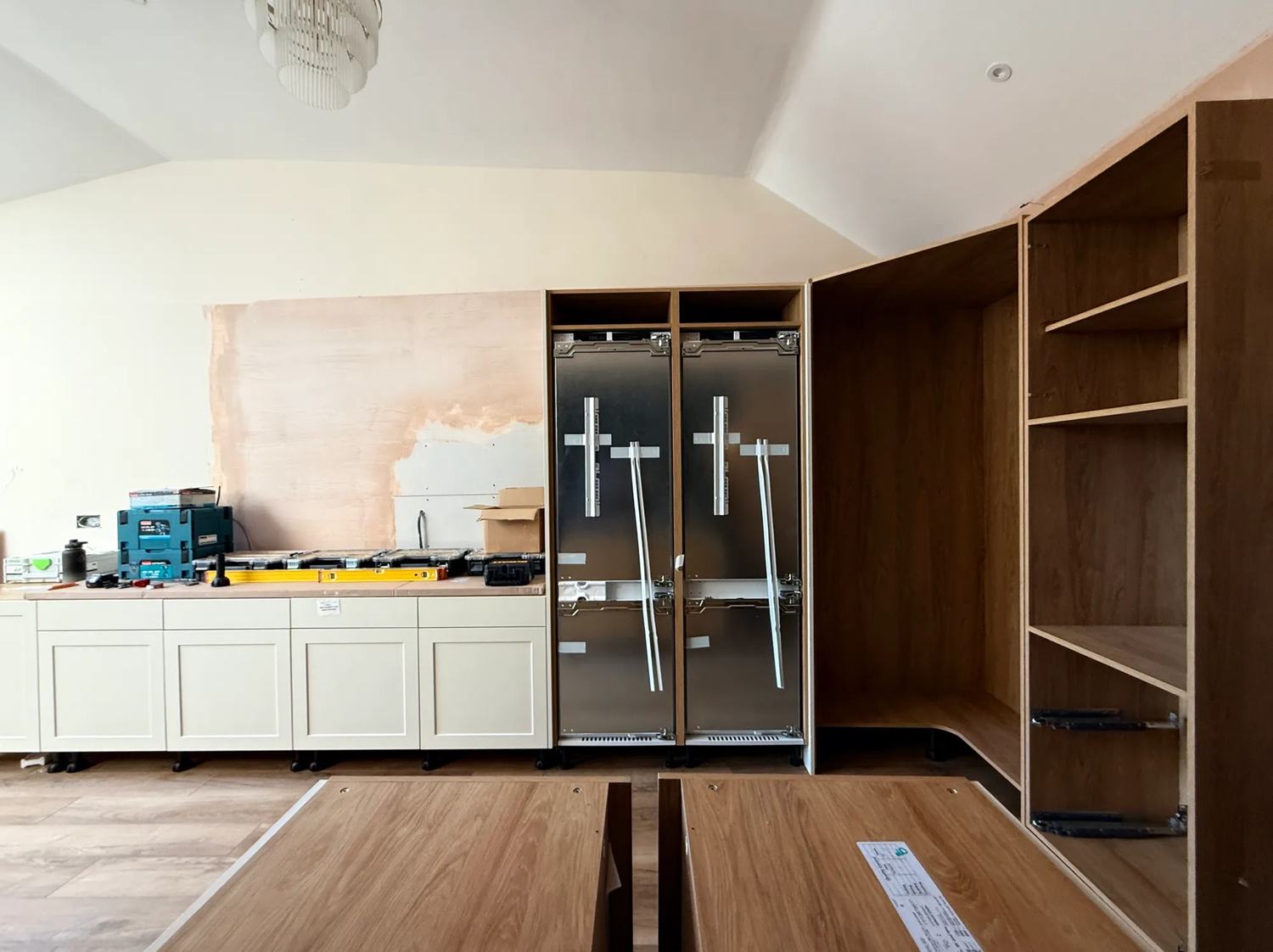 Looking from the kitchen island to the back wall with the lower bar units, the fridge freezers, pantry anc oven units.