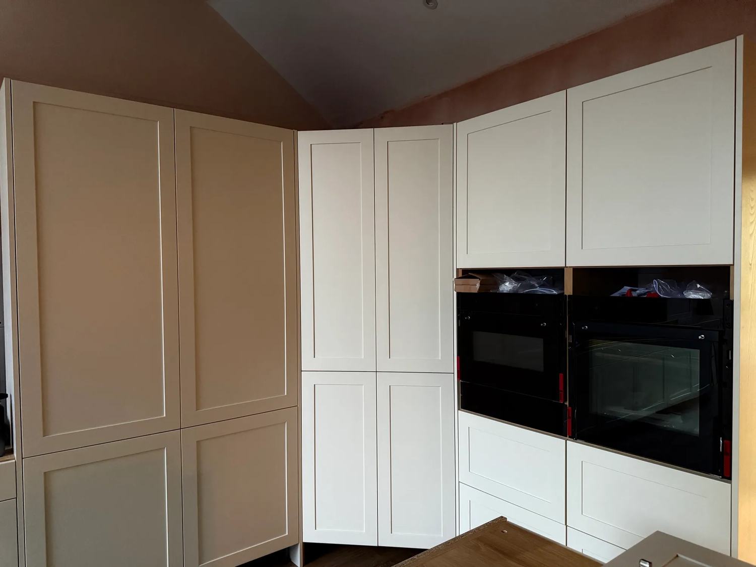 The back corner of the kitchen with the fridge freezers, the pantry and the ovens.