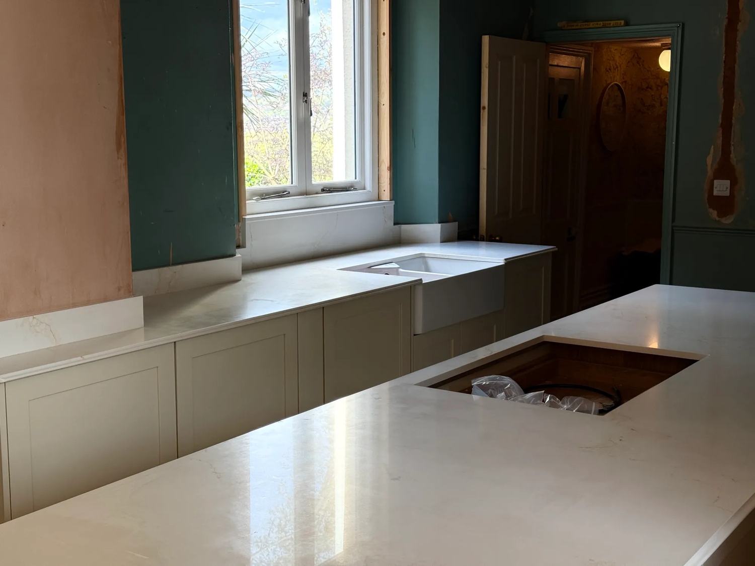 The kitchen island in the foreground and the sink units in the background.