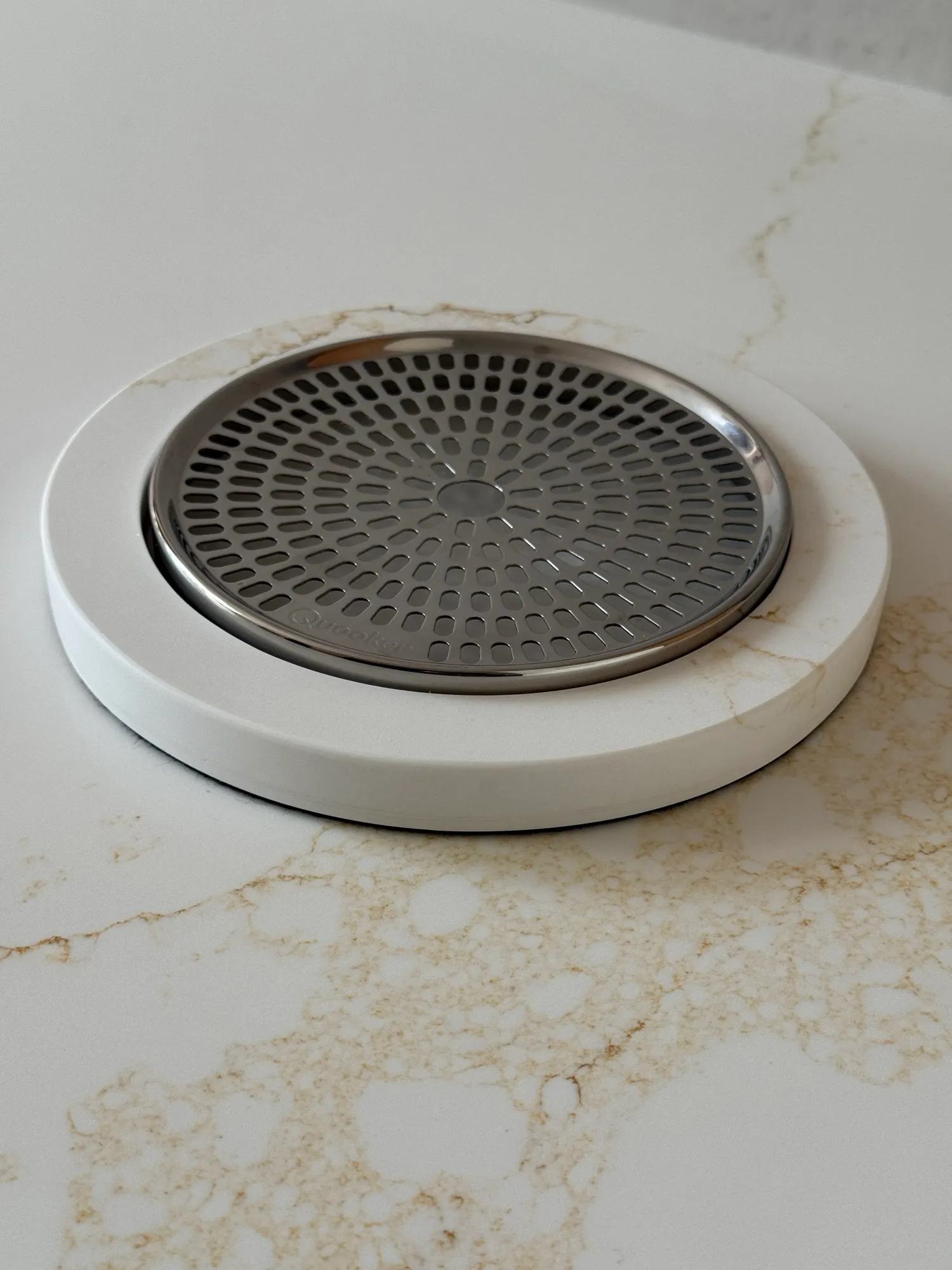 The custom quooker drip tray made from the same quartz as the countertop.
