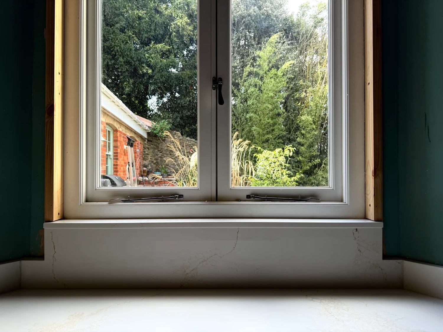 The countertop section which sits behind the sink and runs up to the window.