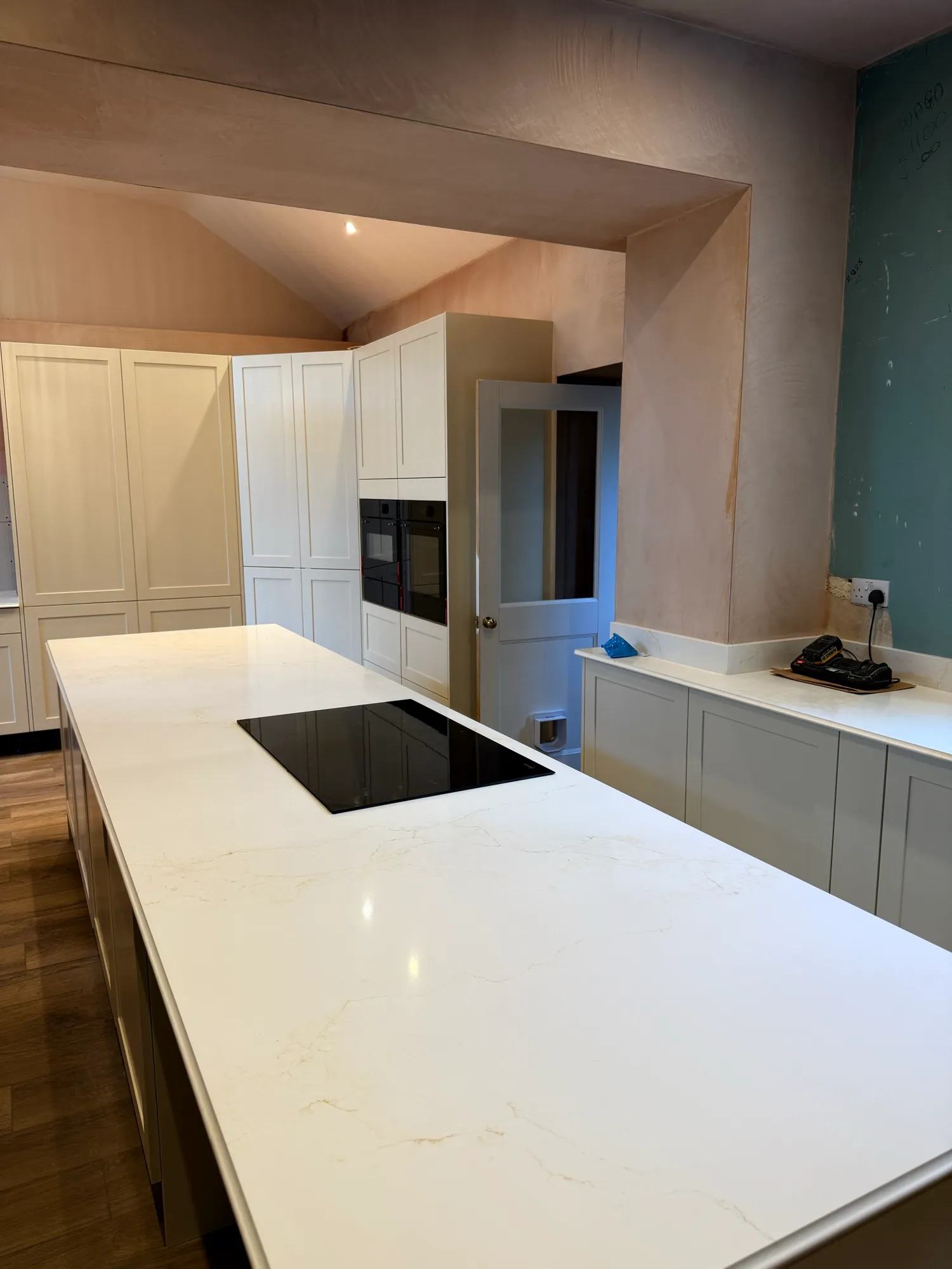 Looking over the island towards the ovens and the new door.